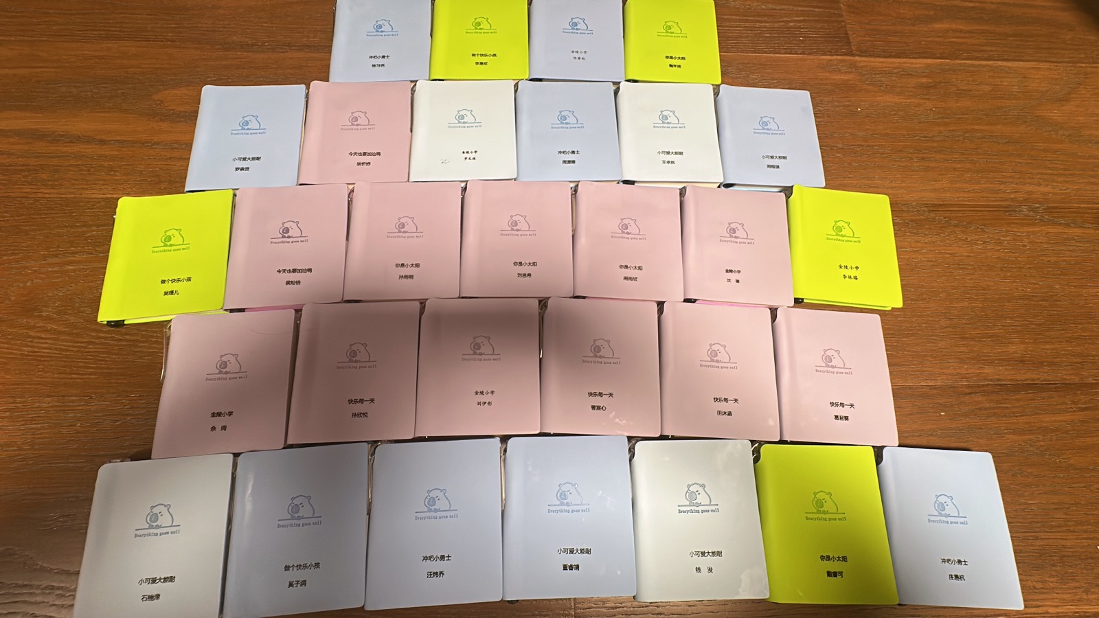30 多本写着同学名字的小本子整齐排成一片